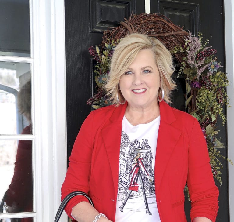 Fashion Blogger 50 Is Not Old looks stylish in a graphic tee and a red jacket