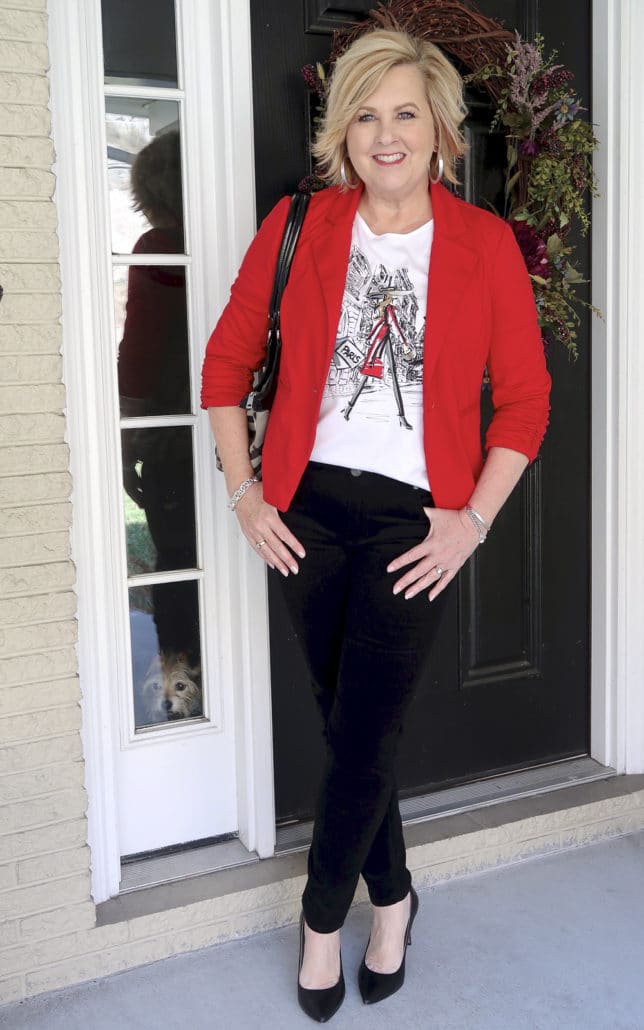 Fashion Blogger 50 Is Not Old looks stylish in a graphic tee and black velvet pants