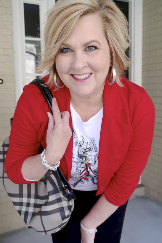 Fashion Blogger 50 Is Not Old looks stylish in a graphic tee with a red jacket