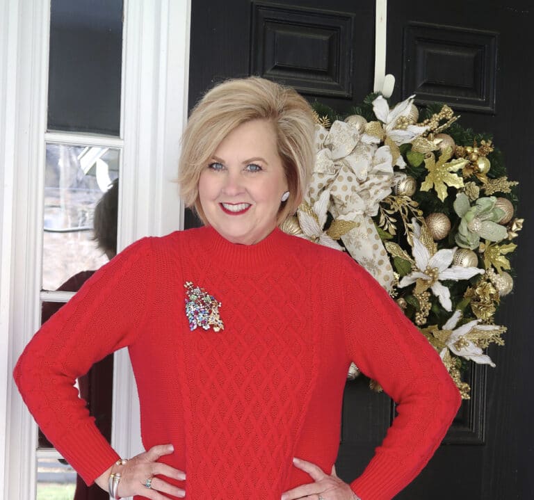 Fashion Blogger 50 is not old wearing a red sweater dress with Christmas pins