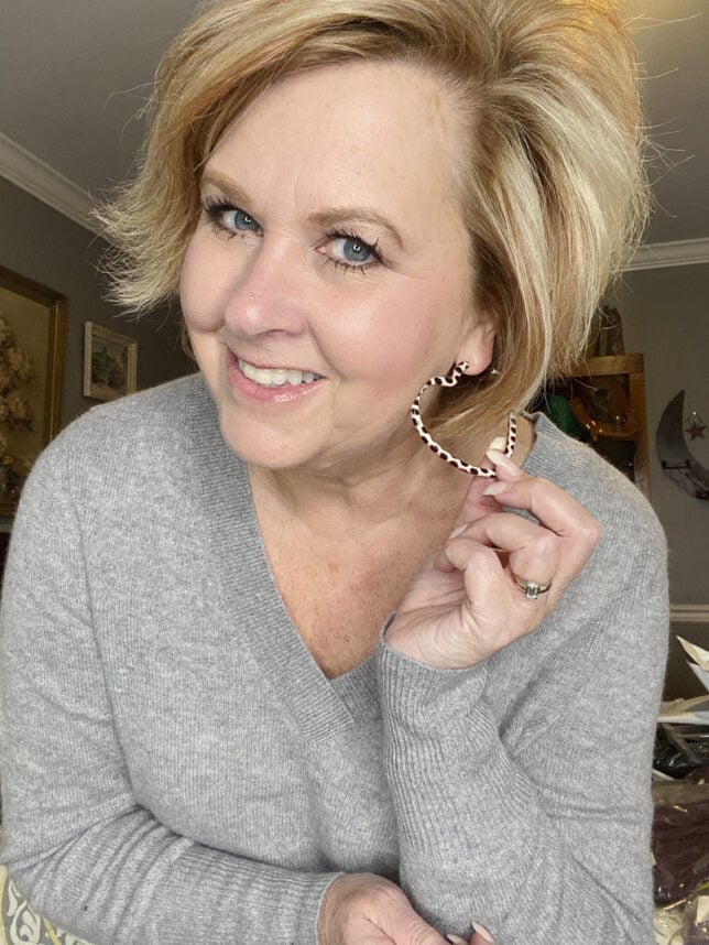 Fashion Blogger 50 Is Not Old holds a try on session shows a large spotted heart earring