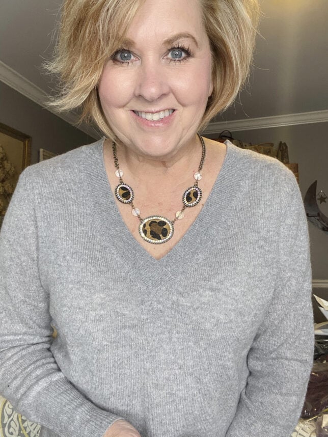 Fashion Blogger 50 Is Not Old holds a try on session shows a leopard print necklace