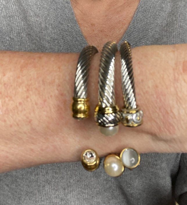 Fashion Blogger 50 Is Not Old holds a try on session and shows an up close photo of silver bracelets