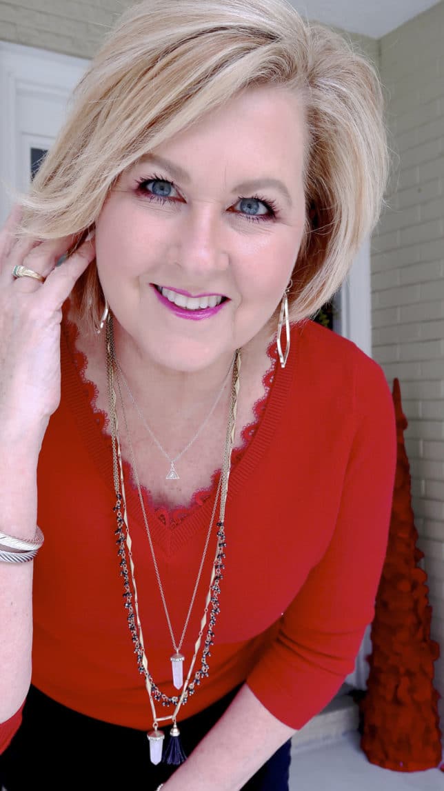 Fashion Blogger 50 Is Not Old is wearing a classical look with a red v-neck sweater and gorgeous gold jewelry