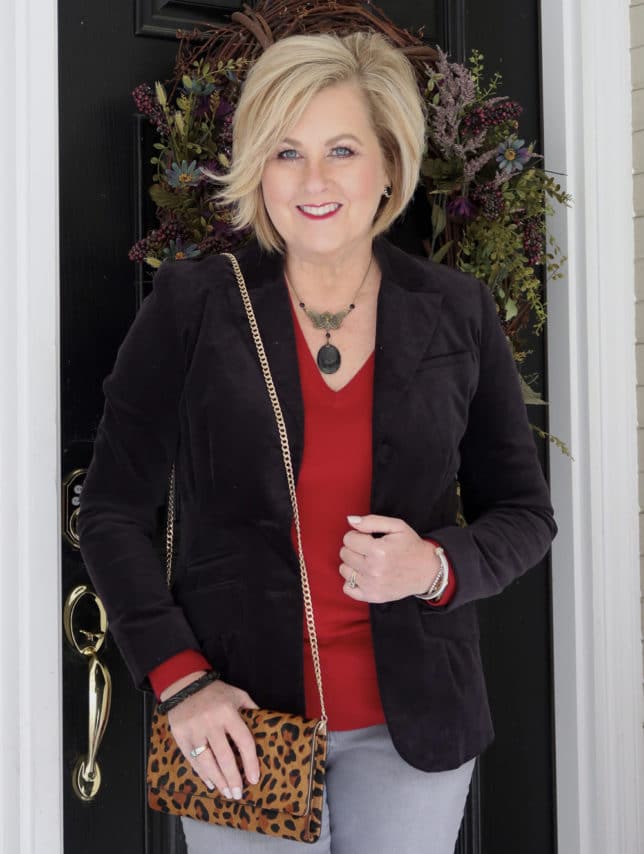 A Black velvet jacket, a red v neck sweater, and a vintage necklace from Fashion Blogger 50 Is Not Old