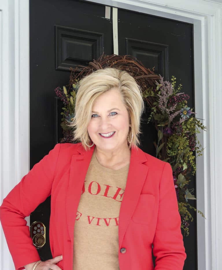 Fashion Blogger 50 Is Not Old wearing a red blazer and a tan sweater