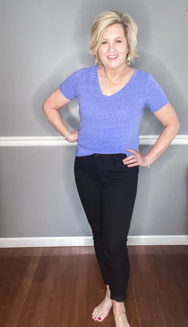 Fashion Blogger 50 Is Not Old wearing a pair of black skinny jeans and a blue v-neck t-shirt