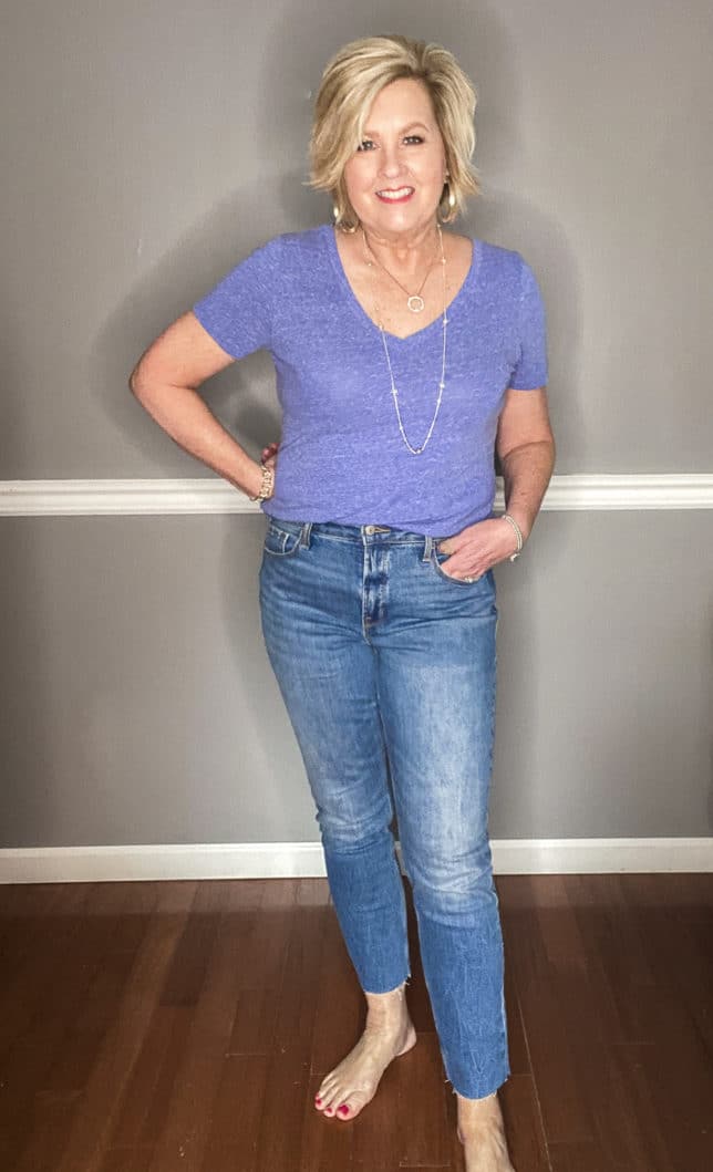 Fashion Blogger 50 Is Not Old wearing a pair of straight raw hem jeans from Old Navy and a blue v-neck t-shirt