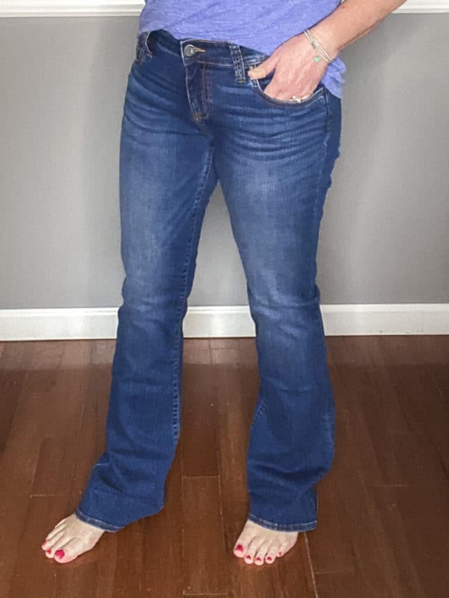 Fashion Blogger 50 Is Not Old showing a pair of flare jeans from Kut From The Kloth and a blue v-neck t-shirt