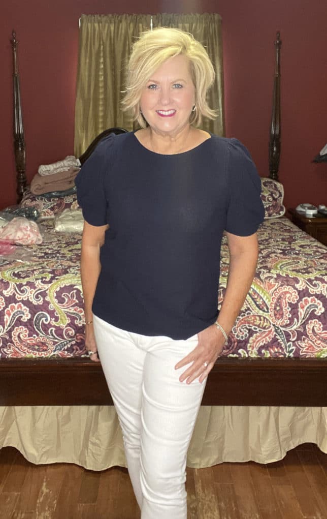 Fashion Blogger 50 Is Not Old is wearing a navy blue sweater with white skinny jeans