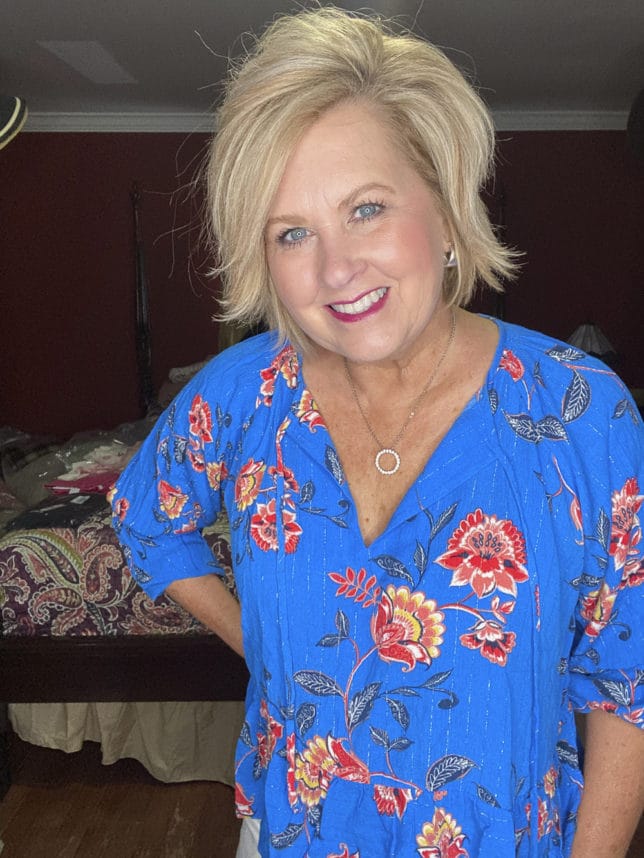 Fashion Blogger 50 Is Not Old is wearing a bright blue floral top with metallic stripes