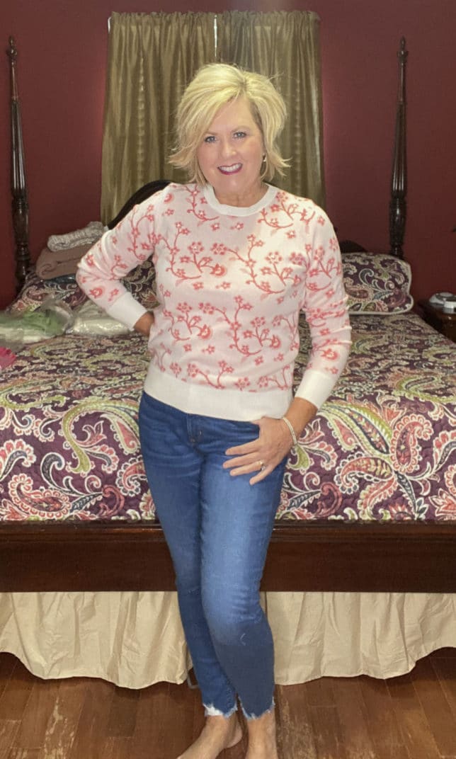 Fashion Blogger 50 Is Not Old is wearing a floral sweater with skinny jeans