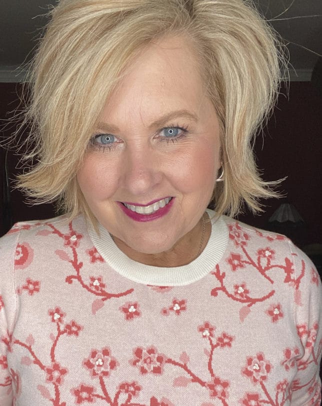 Fashion Blogger 50 Is Not Old is wearing a floral sweater with embroidered centers