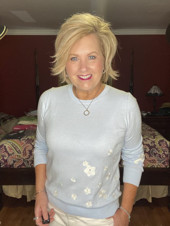 Fashion Blogger 50 Is Not Old is wearing a pale blue sweater with white embroidered flowers