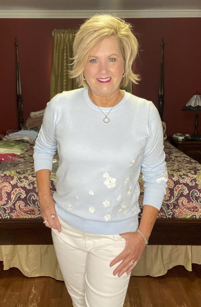 Fashion Blogger 50 Is Not Old is wearing a pale blue sweater with white skinny jeans