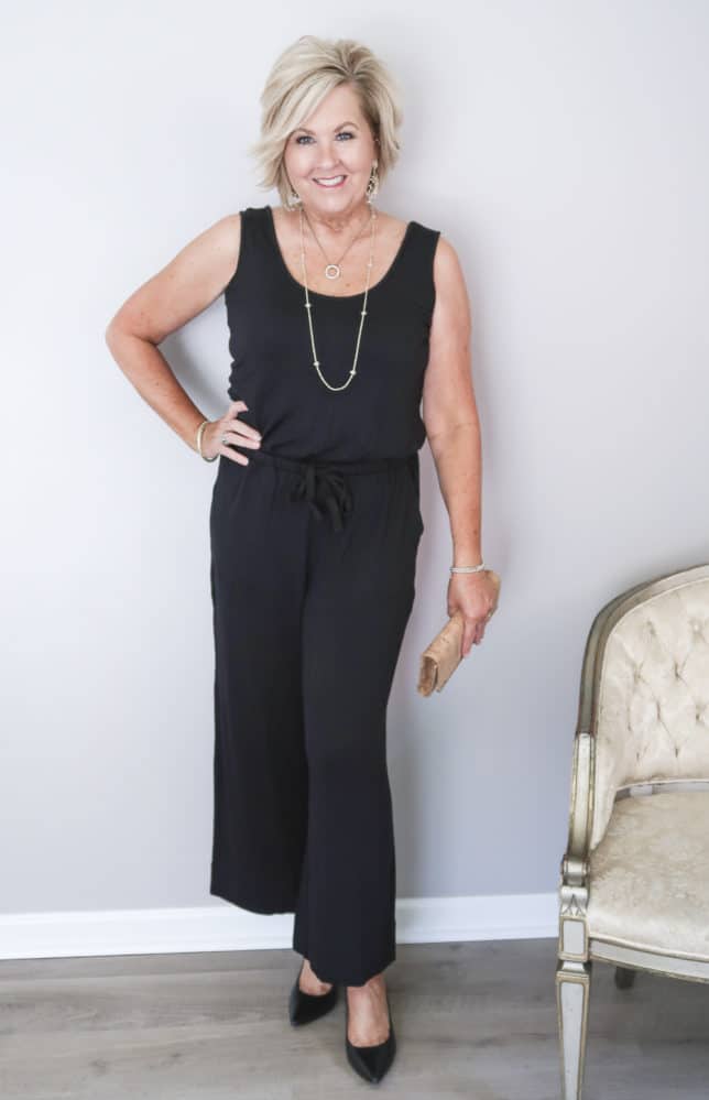 50 Is Not Old is wearing a black sleeveless wide leg ankle length jumper with black pumps