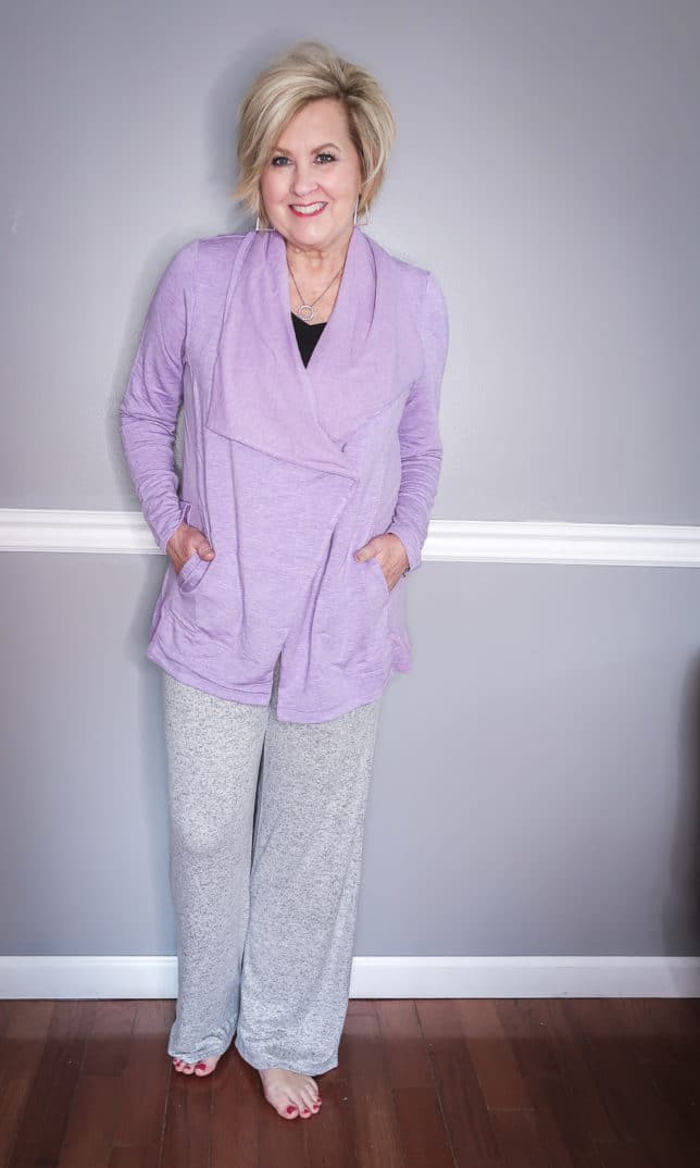 Fashion Blogger 50 Is Not Old is wearing a black tank top with a lilac cardigan and a gray loungewear pant 
