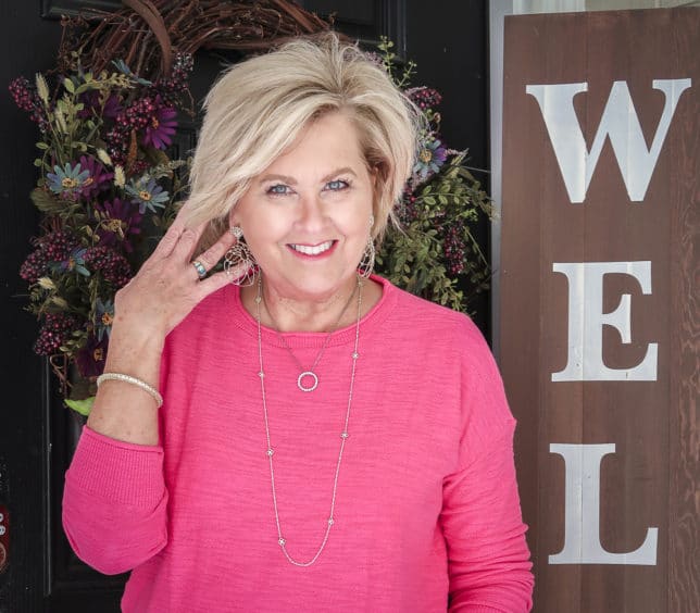 Fashion Blogger 50 Is Not Old is wearing a pink crop sweater and gold jewelry from Kendra Scott