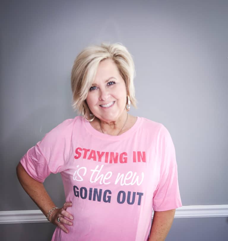 Fashion Blogger 50 Is Not Old is wearing a pink PJ top that says Staying in is the new Going Out