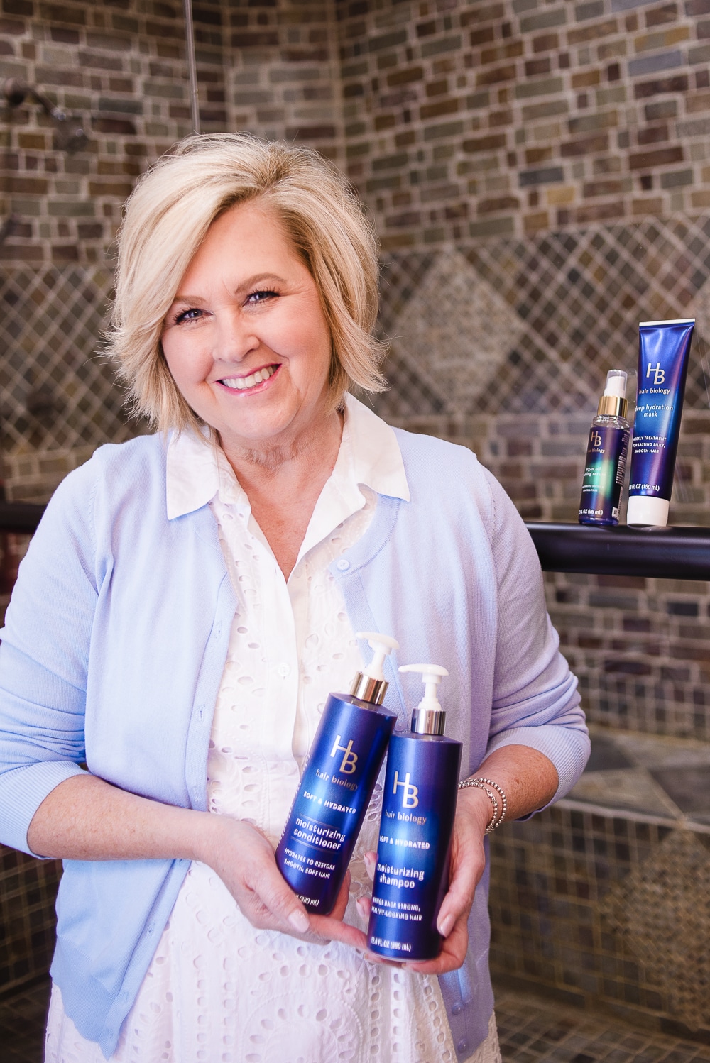 Fashion Blogger 50 Is Not Old holding shampoo and conditioner from Hair Biology