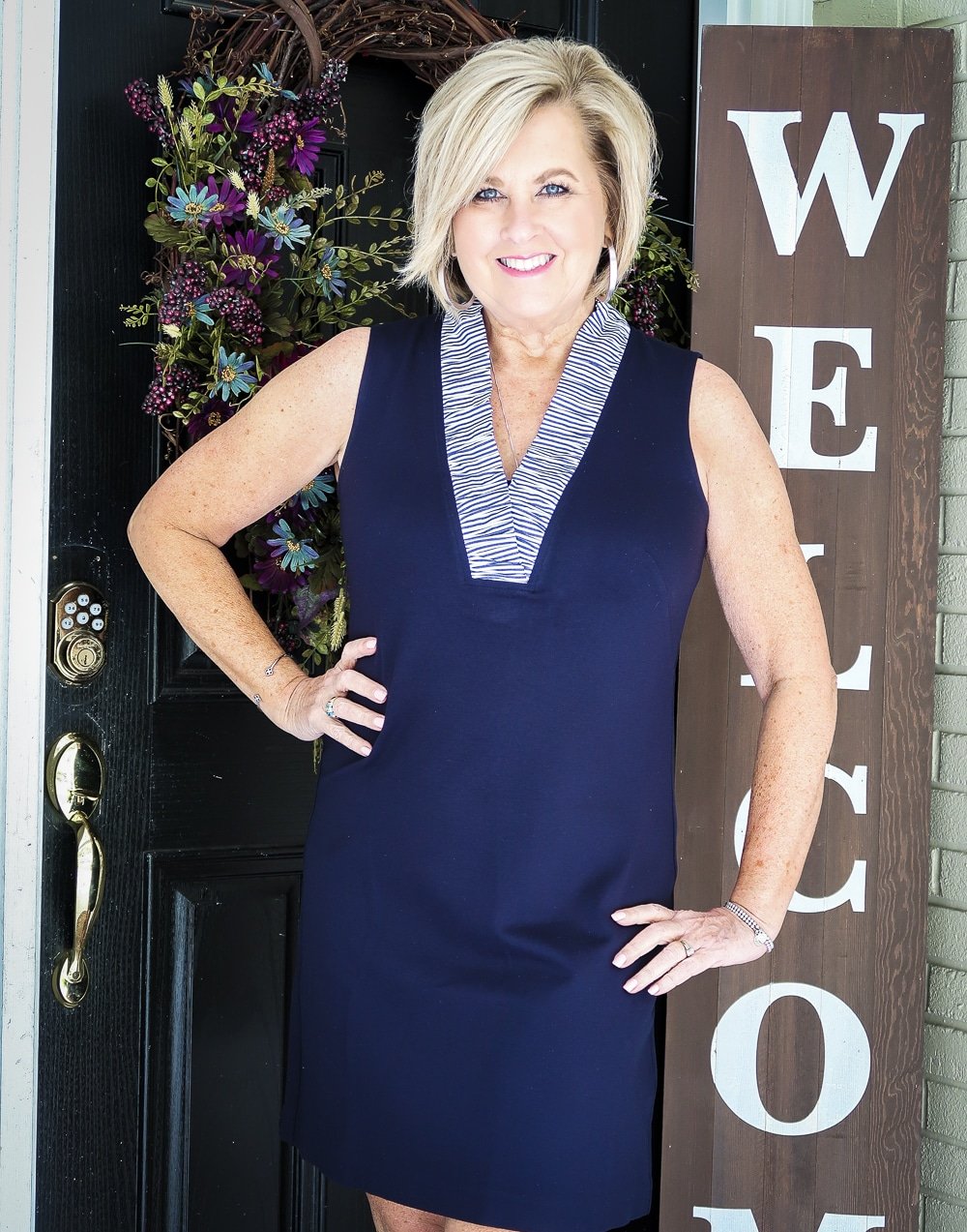 Fashion Blogger 50 Is Not Old is celebrating turning 60 with a navy sheath dress with a striped ruffled neckline 