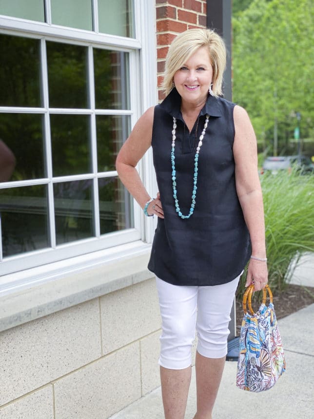 Fashion Blogger 50 Is Not Old is wearing a black tunic with white bermuda shorts