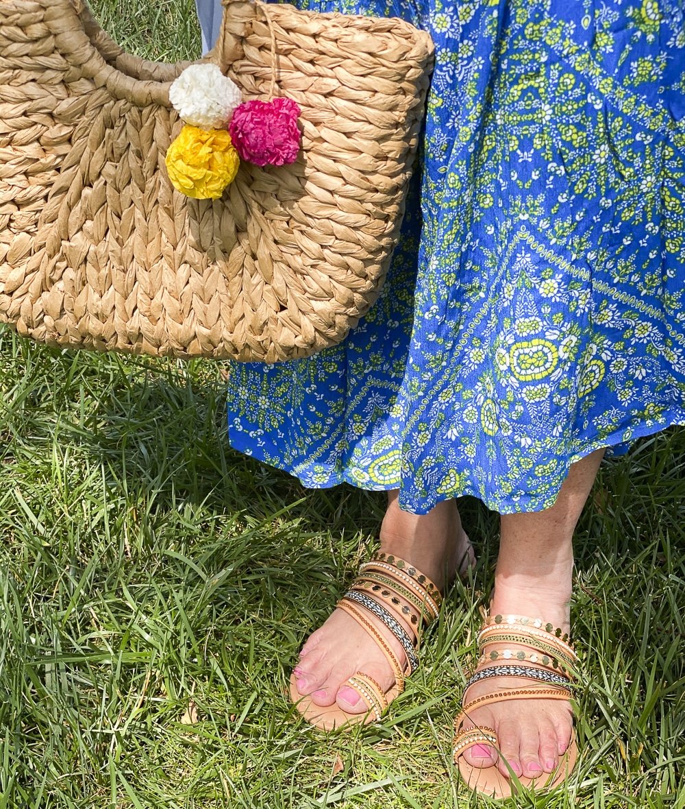 Fashion Blogger 50 Is Not Old is wearing embellished sandals, and a straw handbag