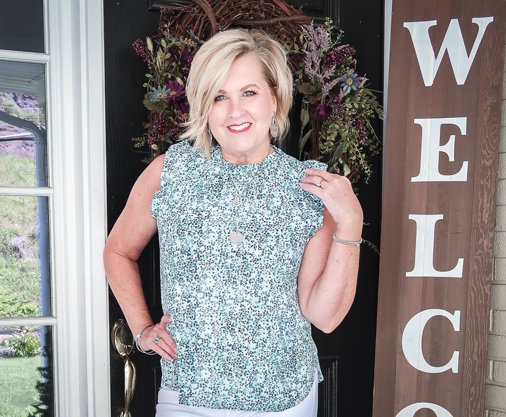 Fashion Blogger 50 Is Not Old is wearing a high neck blue top with flutter sleeves