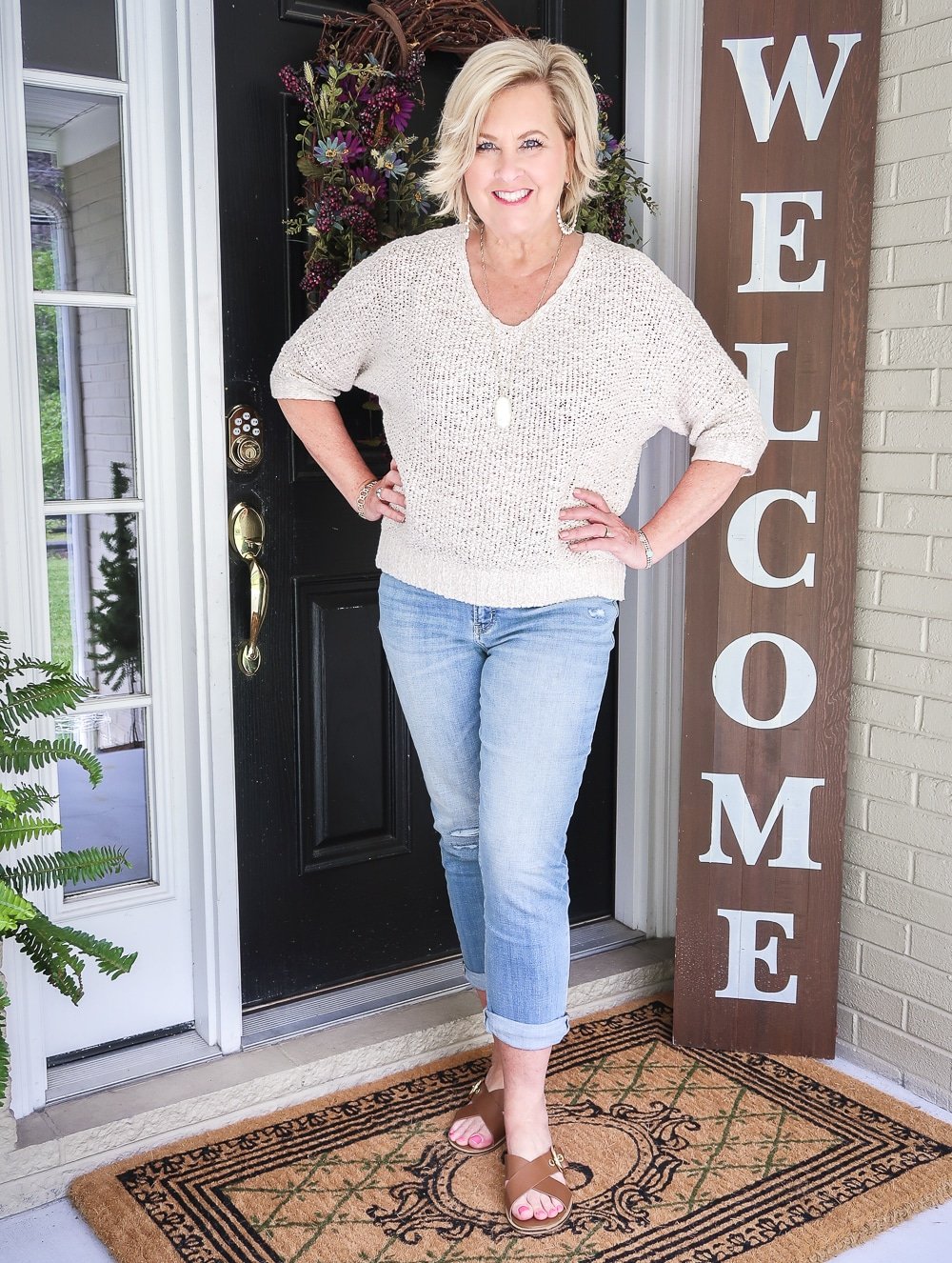 Fashion Blogger 50 Is Not Old is wearing a Sand colored sweater with a pair of girlfriend distressed crop jeans and brown leather sandals
