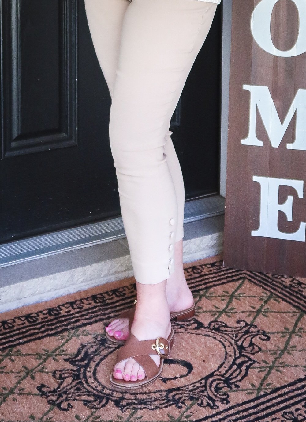 Fashion Blogger 50 Is Not Old is wearing pair of beige pants and brown leather sandals
