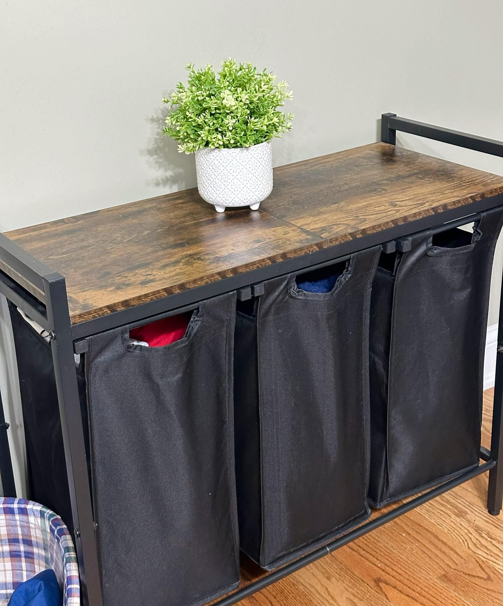 Over 50 Fashion Blogger, Tania Stephens is holding a few of her favorite things, a laundry hamper