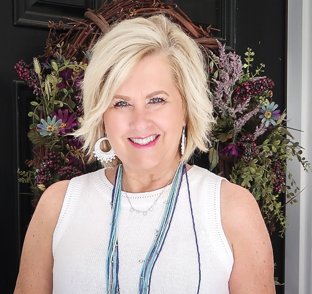 Fashion Blogger 50 Is Not Old is wearing a classic blue and white outfit. A white sweater with white earring