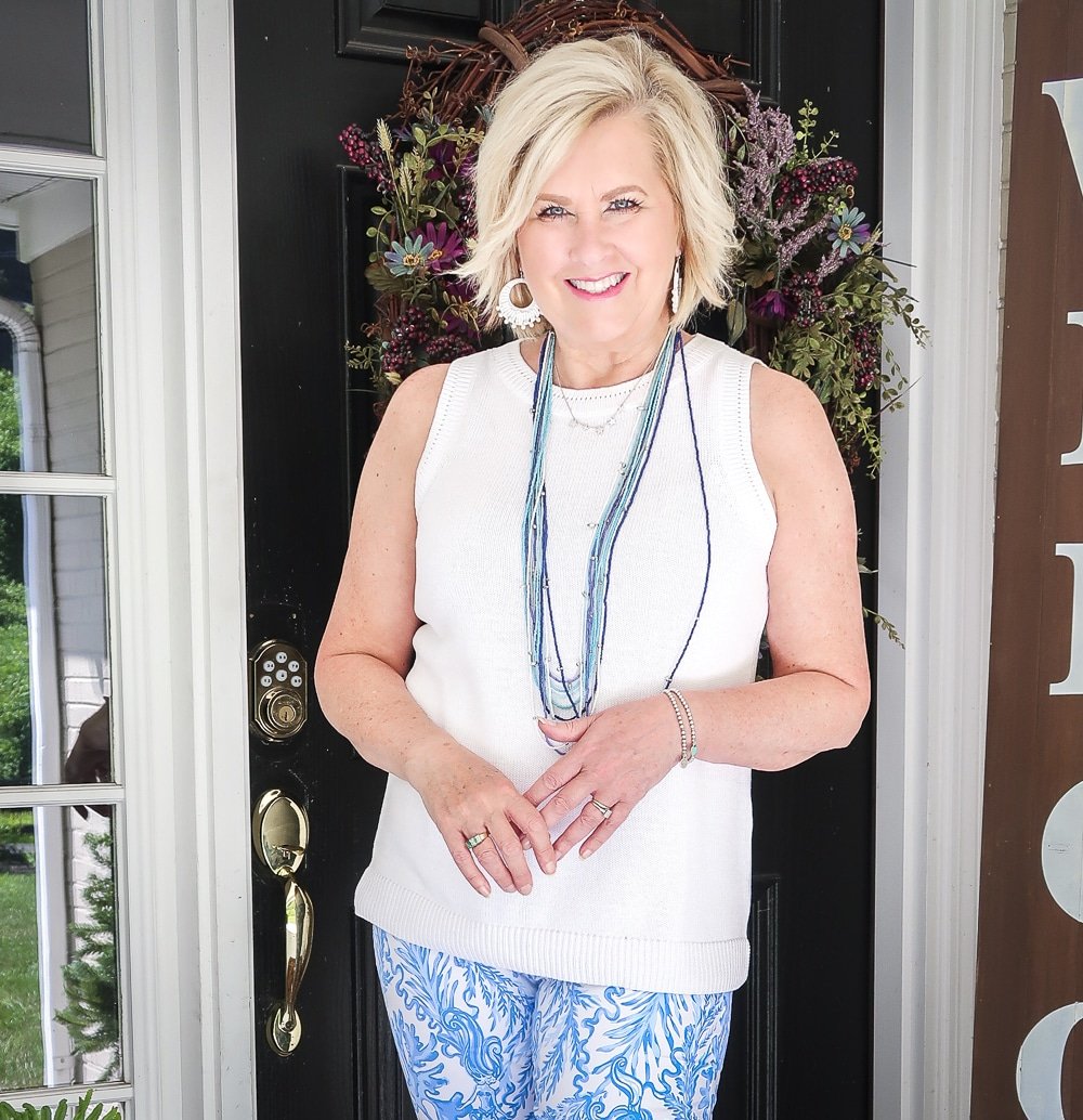 Fashion Blogger 50 Is Not Old is wearing a classic blue and white outfit. A white sweater with a blue multi strand necklace