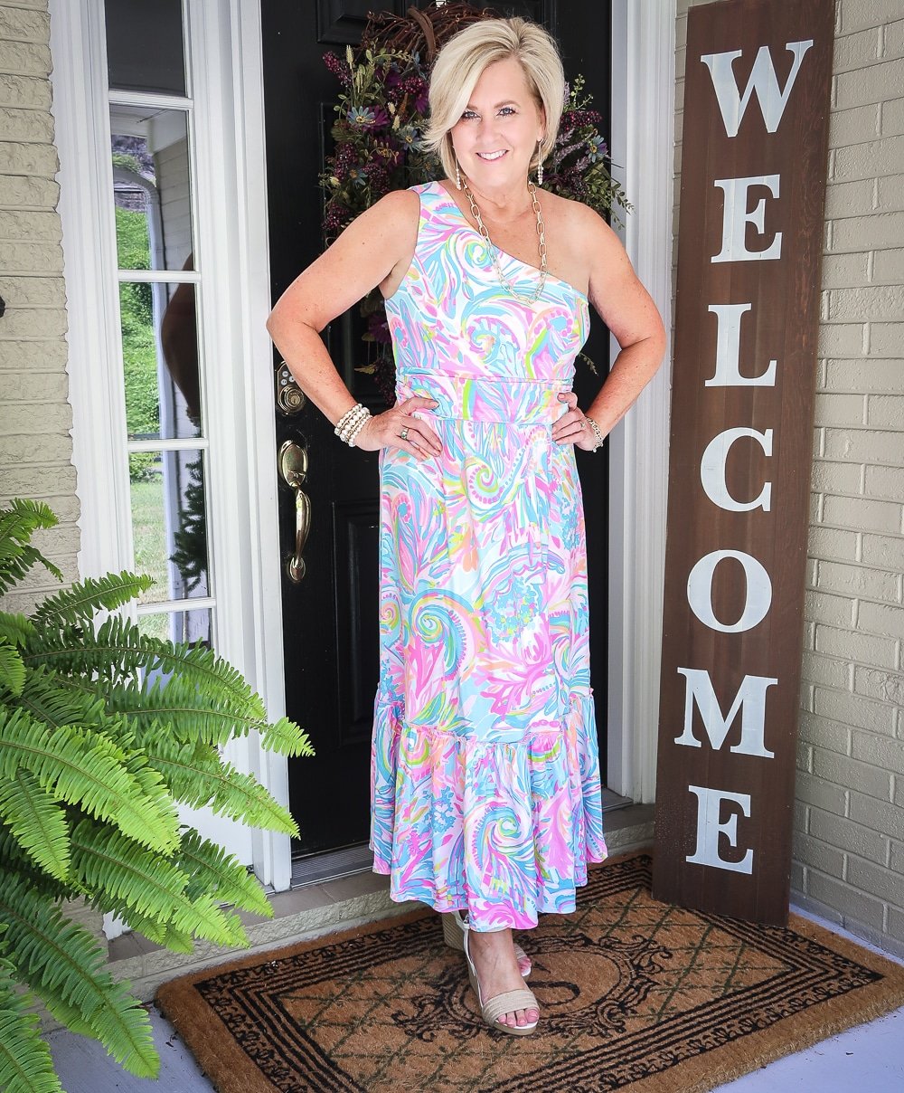 Fashion Blogger 50 Is Not Old is styling a one shoulder Lilly Pulitzer maxi dress with gold jewelry from Kendra Scott