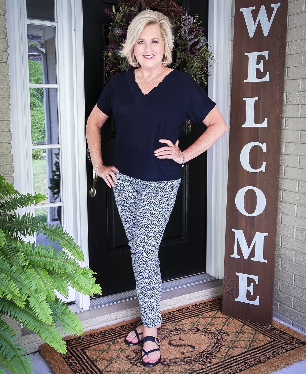 Fashion Blogger 50 Is Not Old wearing a dark navy linen top with a lace neckline and printed ankle pants with navy sandals from Talbots