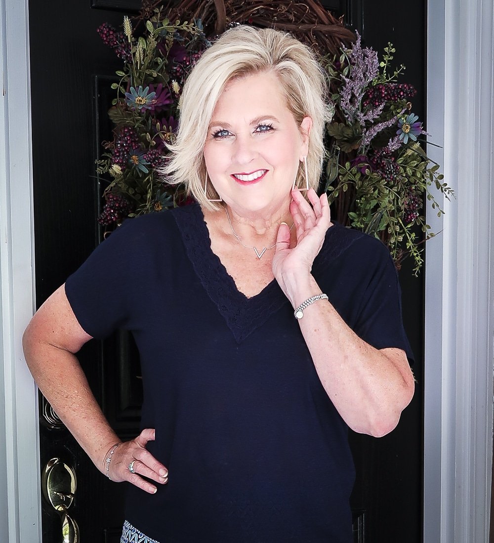 Fashion Blogger 50 Is Not Old wearing a dark navy linen top with a lace neckline and silver jewelry