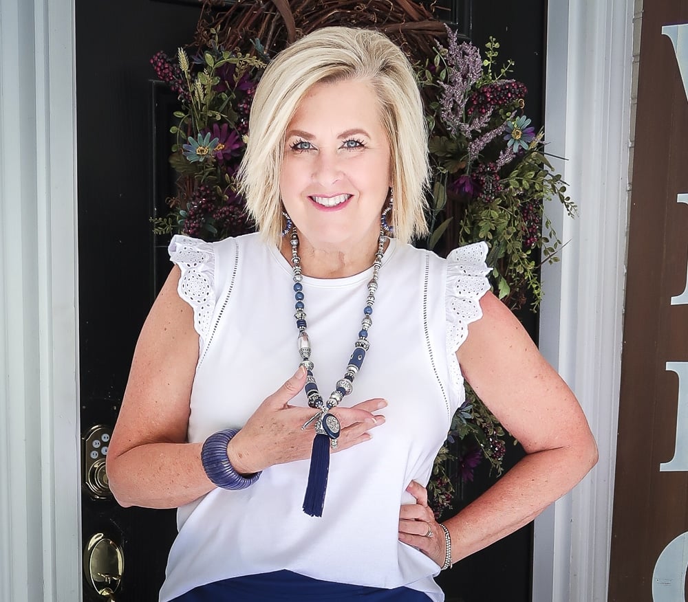 Fashion Blogger 50 Is Not Old is wearing an eyelet flutter sleeve top with navy and silver jewelry