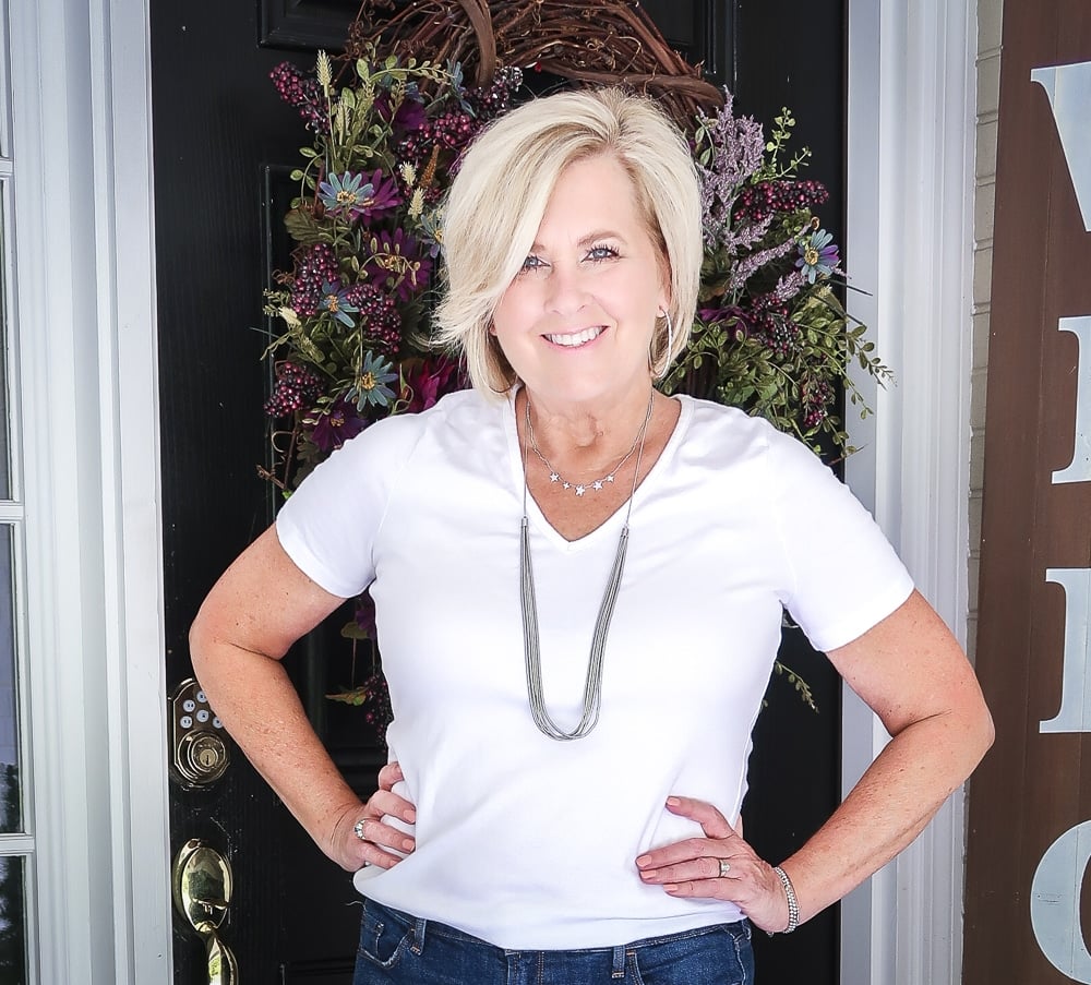 Fashion Blogger 50 Is Not Old is wearing a white v neck t-shirt, distressed jean shorts