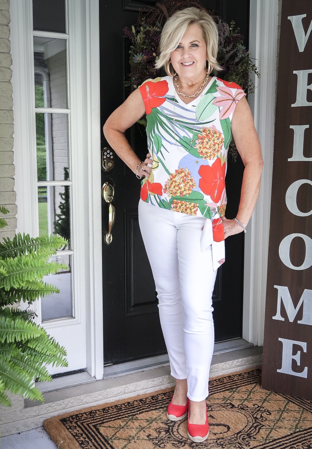 Fashion Blogger 50 Is Not Old is wearing a bright and bold side-tie sweater with a pair of white no-stain jeggings and a pair of red espadrilles