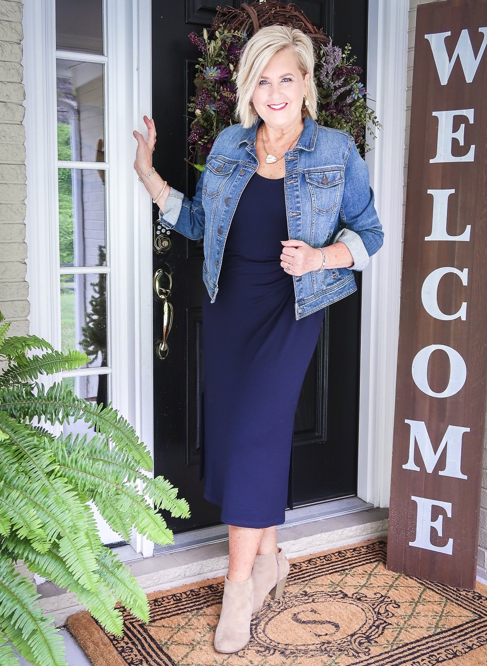 Fashion Blogger 50 Is Not Old is wearing a navy midi dress in all of the seasons. In the fall of the year, she added a denim jacket and ankle booties from Old Navy