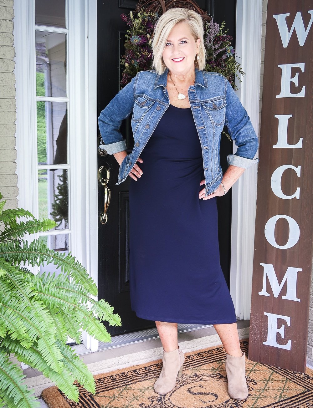 Fashion Blogger 50 Is Not Old is wearing a navy midi dress with a denim jacket and ankle booties from Old Navy