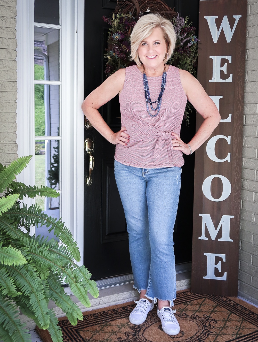 Fashion Blogger 50 Is Not Old is ready for celebrating Labor Day in her top twist top, distressed jeans, and Sperry sneakers