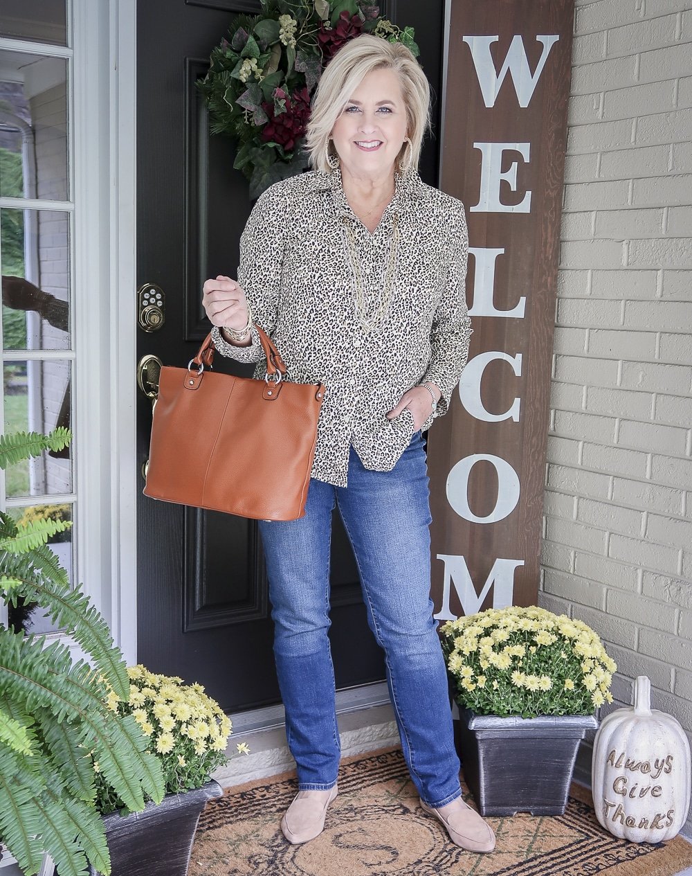 Fashion Blogger 50 Is Not Old is wearing an animal print button up shirt with straight leg jeans and camel loafers