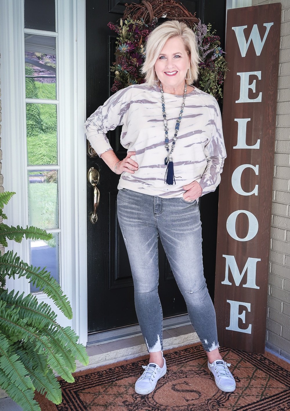 Fashion Blogger 50 Is Not Old is wearing a tie-dye sweatshirt with a pair of washed gray jeans from Kut From The Kloth with Sperry sneakers