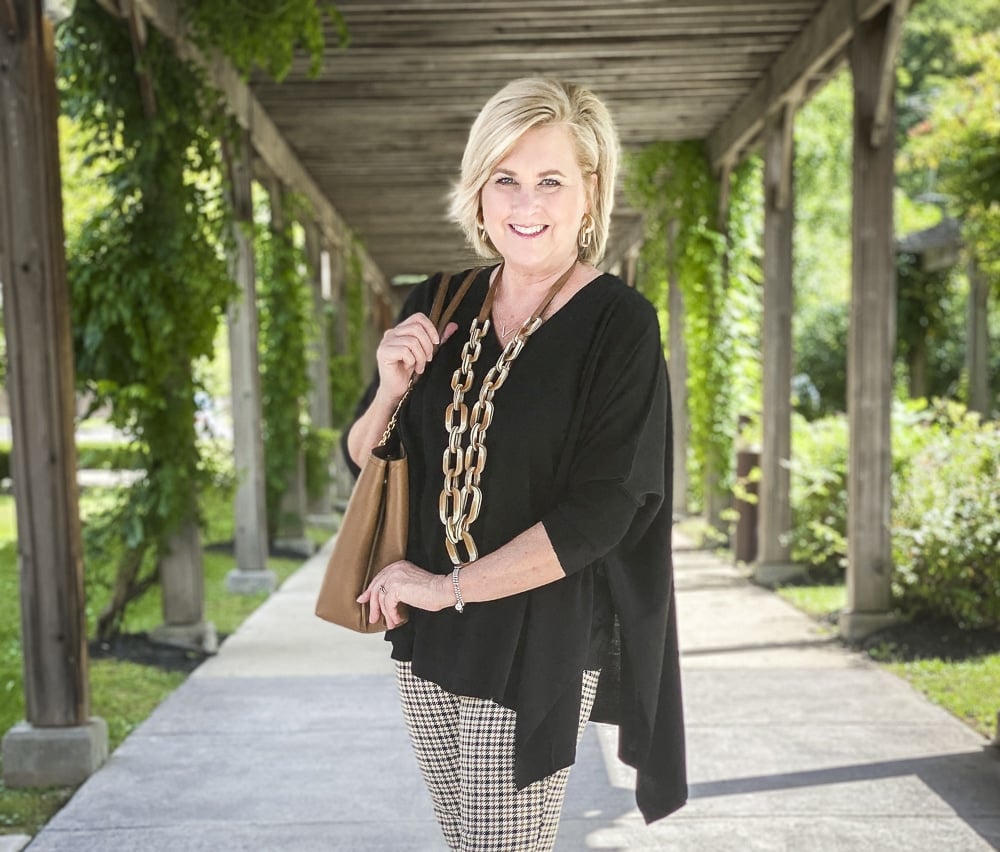 Fashion Blogger 50 Is Not Old is wearing plaid pants in the fall and a black poncho