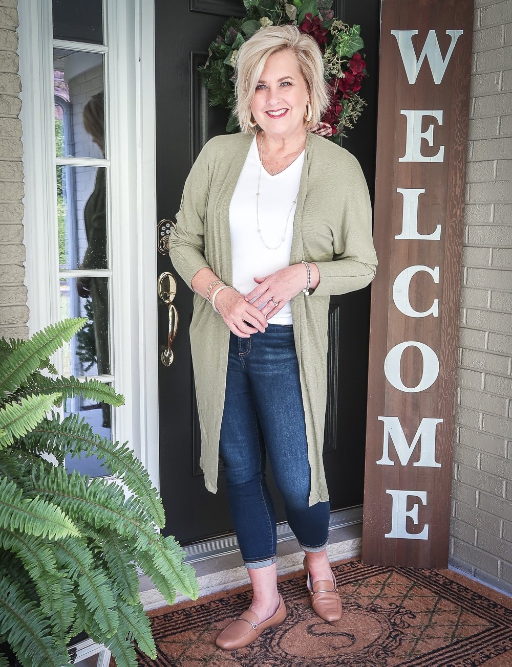 Fashion Blogger 50 Is Not Old is doing a Tuesday Try-On Session with Target and styling a long olive cardigan, a white v-neck tee shirt, and dark jeans from Chico's