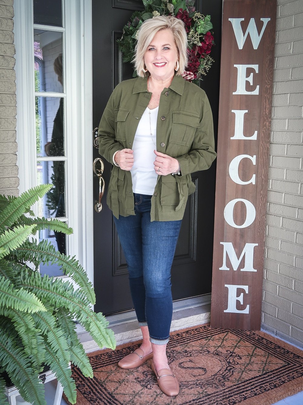 Fashion Blogger 50 Is Not Old is doing a Tuesday Try-On Session with Target and styling a green trucker jacket, a white v-neck tee shirt, and dark jeans from Chico's