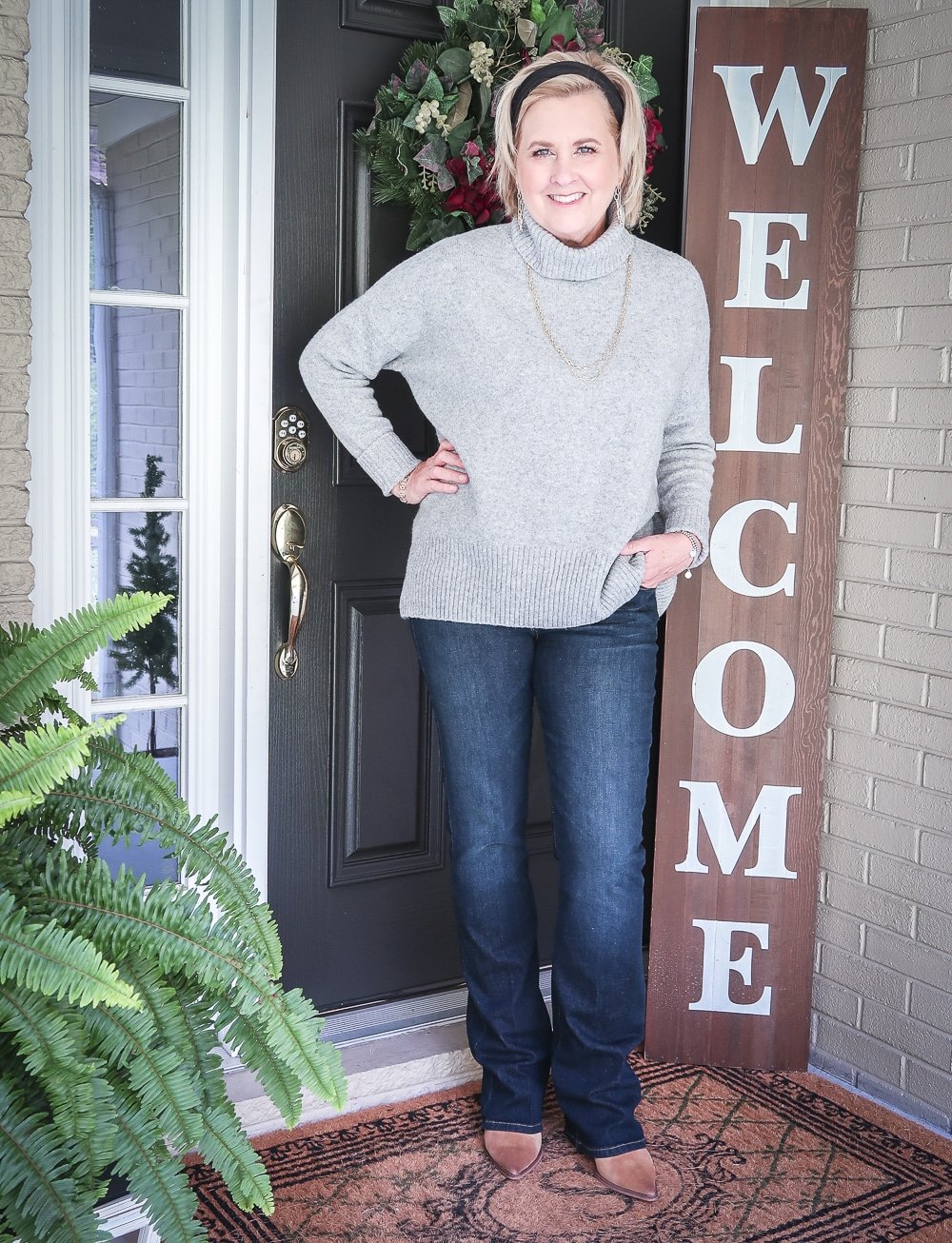 Fashion Blogger 50 Is Not Old is wearing a chunky sweater, bootcut jeans, and ankle boots for fall