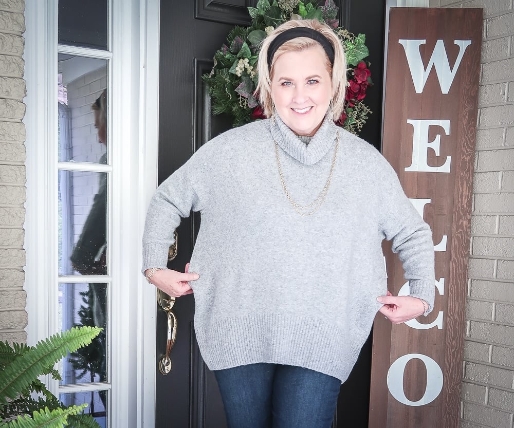 Fashion Blogger 50 Is Not Old has her hair pulled back in a headband, and is wearing a chunky sweater that is too big