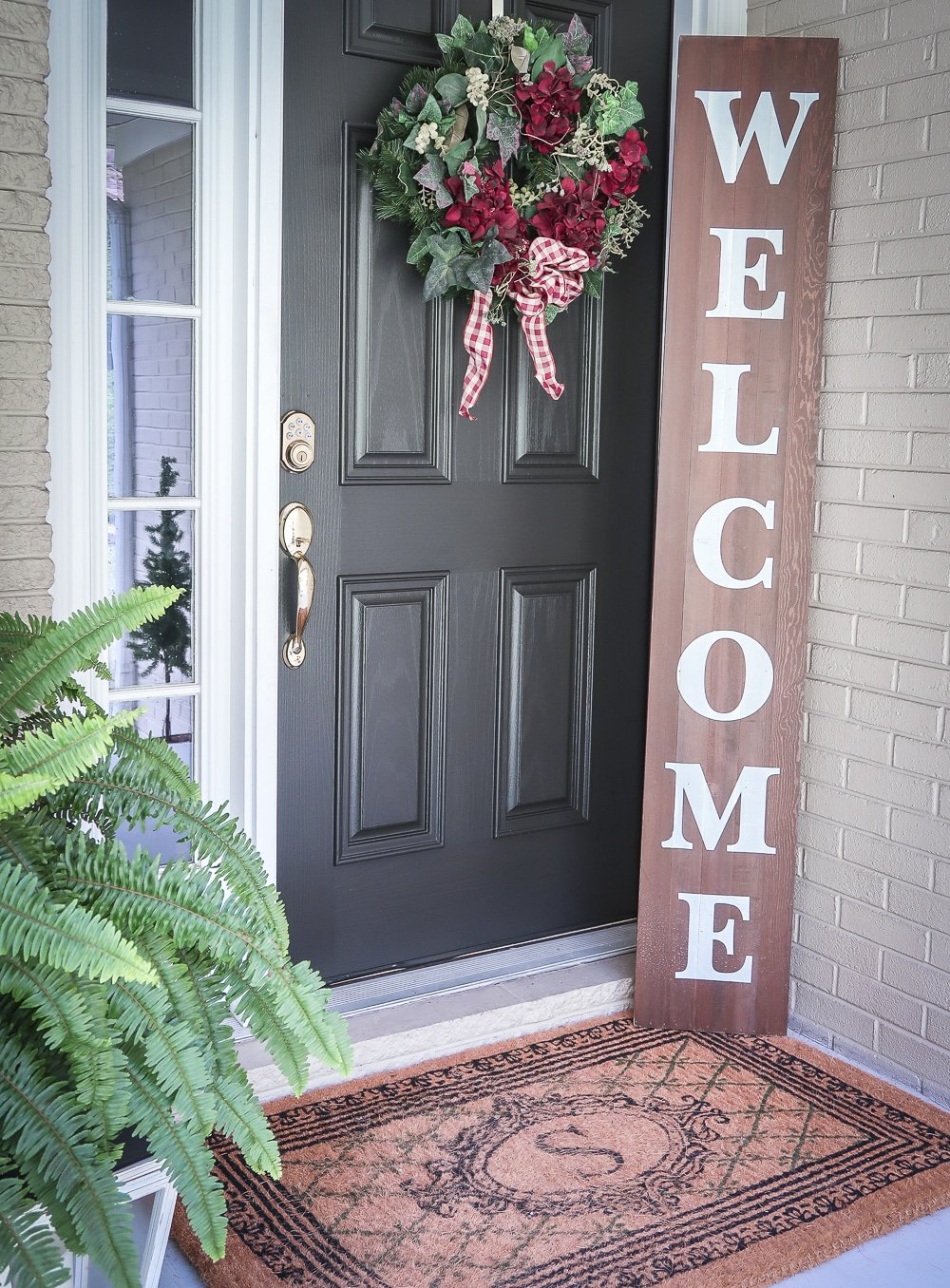 Fashion Blogger 50 Is Not Old is showing a black front door with a wreath and a Welcome sign